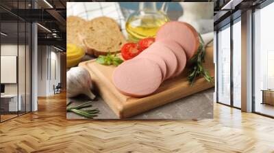 Sausage, bread, spices, towel and board on grey background, close up Wall mural