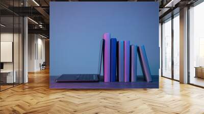 Stack of books and laptop on gray background Wall mural