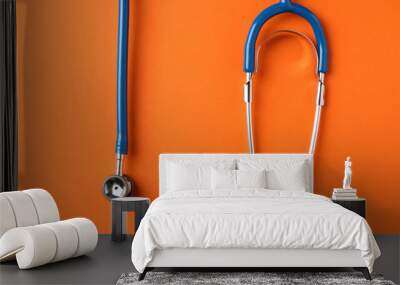 Stethoscope on orange background, space for text. Healthcare Wall mural