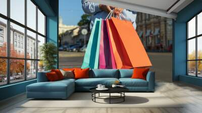 Woman with colorful shopping bags on road in the city Wall mural