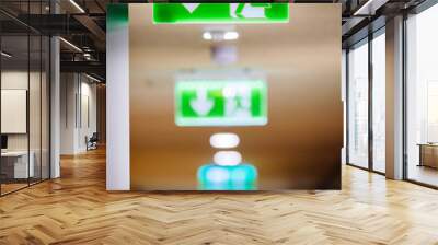 Green Exit Sign pointing to the nearest emergency exit in a modern office interior Wall mural