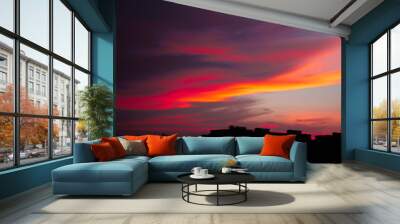 Colorful dark dramatic sky with cloud at sunset and builings in the darkness Wall mural