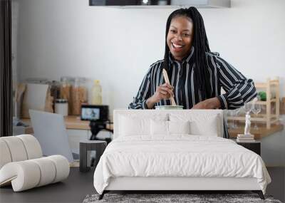 African american woman cooking vlogger recording video in kitchen at home Wall mural