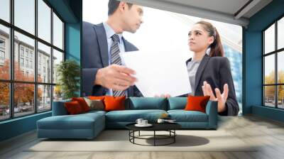 Asian businesswoman and businessman standing and discussing document Wall mural