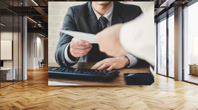 Businessman passing document to manager in the office Wall mural