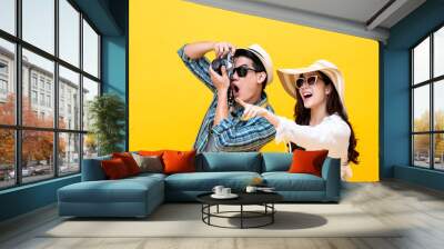 Excited young Asian couple tourist in colorful yellow background Wall mural