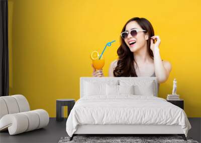 Healthy Asian girl in summer outfit drinking orange juice Wall mural