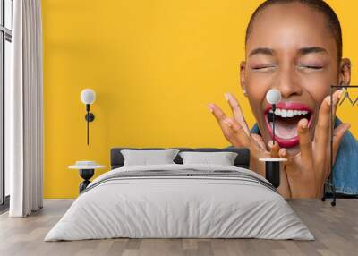 Panoramic close up portrait of ecstatic young African American woman screaming with hands covering mouth isolated studio yellow background Wall mural