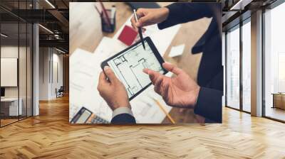 Real estate agent with client or architect team checking a housing model and its blueprints digitally using a tablet Wall mural