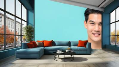 Smiling young handsome Asian man face on light blue banner background Wall mural