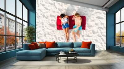 Top view of couple lying on the beach taking a sunbath in summer Wall mural