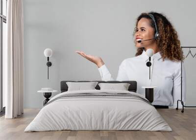 Woman wearing headphones as a call center staff with hand open Wall mural