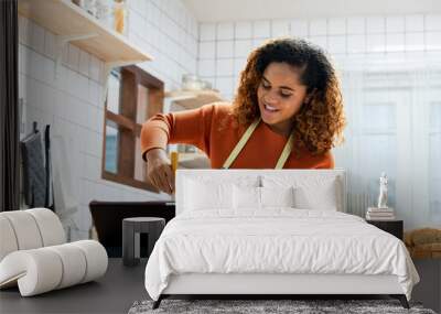 Young African American woman teaching cooking and broadcasting online via tablet computer in kitchen at home Wall mural