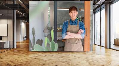 Young entrepreneur Asian man at front door of his own cafe Wall mural