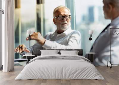 Two business men discussing their business together in a lobby of a hotel. They both wearing white shirt. The older one also wear black jacket. The scene outside is cityscape. Wall mural