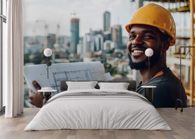 Young worker with construction helmet smiling holding a blueprint Wall mural