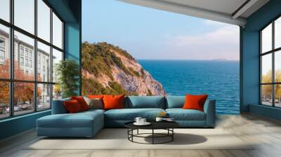 A beautiful view of the ocean with a rocky cliff in the background Wall mural