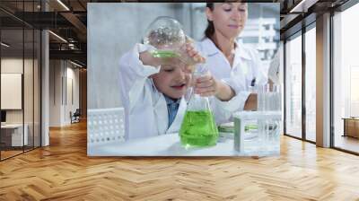 Woman and child boy in science class analyzing experiment by mixing chemical liquid in glass, Science kids modern technology education concept,  Wall mural