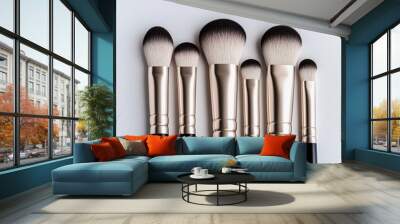 A collection of six makeup brushes featuring soft bristles and sleek black handles, arranged neatly against a light background. Wall mural