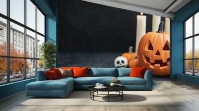 halloween jack-o'-lantern with burning candles, pumpkins, and skulls on black background - festive spooky autumn decoration Wall mural