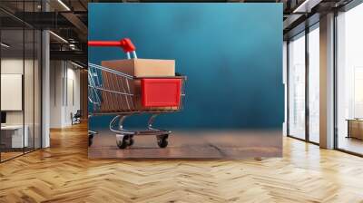 miniature shopping cart with cardboard boxes on wooden surface and blue background - conceptual symbol of online shopping, e-commerce, and retail. Wall mural