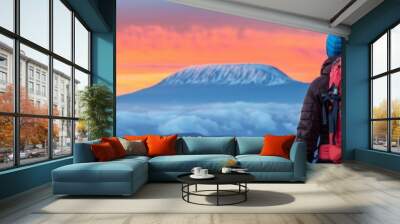 two hikers admire breathtaking sunrise over majestic mountain peak with clouds in the valley - adventure, exploration, and scenic beauty Wall mural