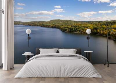 Drone shot of the water of New Croton Reservoir on a sunny day in autumn with a blue cloudy sky Wall mural