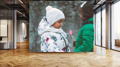 african kids showing love with a heart shaped toy dresses in winter outfit outdoors  Wall mural