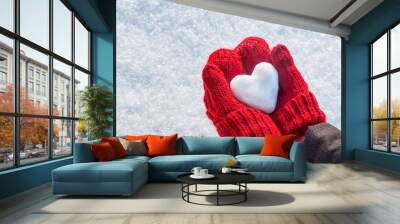 Female hands in knitted mittens with heart of snow in winter day. Love concept. Valentine day background. Wall mural