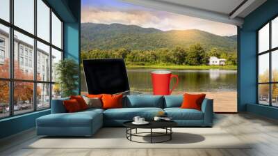 cup of coffee, a computer on a wooden table in the nature park on a sunny afternoon with a copy space, Wall mural