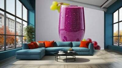 A glass of grape smoothie on a plain white background. Wall mural