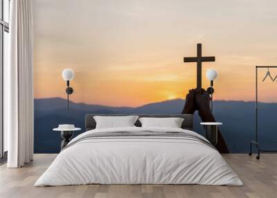 Christian, Christianity, Religion copy space background. Human praying and holding christian cross for worshipping God at sunset background. Wall mural