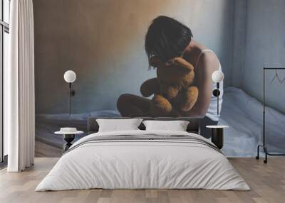 concept photo of Sexual assault, young girl sit on a bed in a bedroom. Wall mural