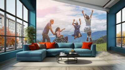 Group of happy disability family holiday concept. Disabled mother in wheelchair and children jumping on mountain Wall mural