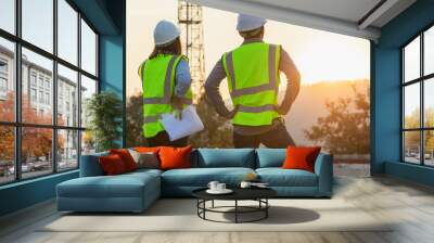 Professional team Engineer managers workers working outdoors with telecommunication antenna and sunset background.. Wall mural