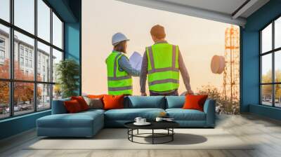 Professional team Engineer managers workers working outdoors with telecommunication antenna and sunset background. Wall mural