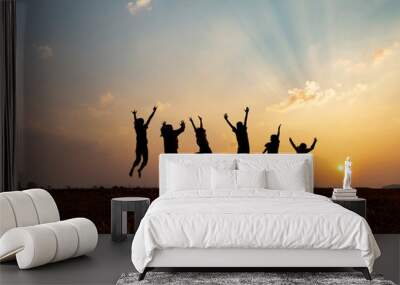 Silhouette group of happy children jumping playing on mountain at sunset, summer time Wall mural