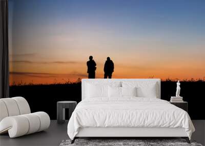 Silhouette of peoples looking at the sunrise or sunset sky Wall mural