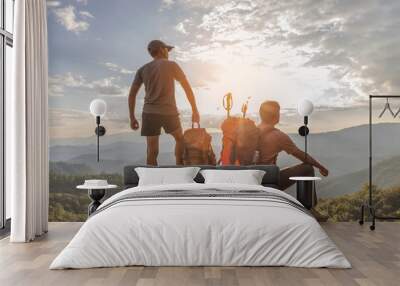 Two hikers with backpack relaxing on top mountain landscape enjoy beautiful landscape view sunset.Hiker men's hiking living healthy active lifestyle. Wall mural