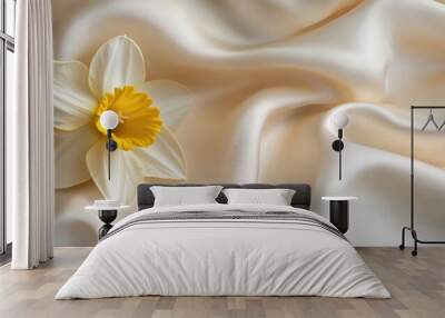 A delicate flower rests on smooth, cream-colored fabric, creating a serene and elegant composition. Wall mural