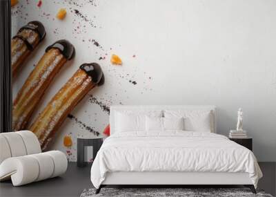 Four churros drizzled with chocolate and sprinkled with sugar on a white background with copy space. Wall mural