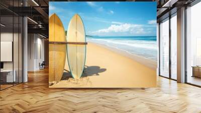 Two surfboards standing on a sandy beach with ocean waves and blue skies. Wall mural