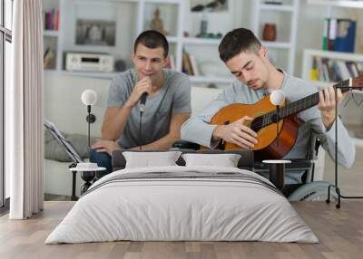 2 male teenagers playing an acoustic guitar and singing Wall mural