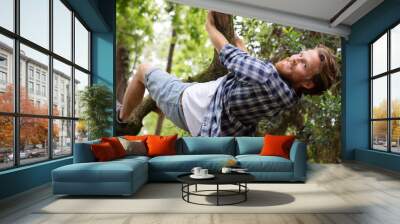 a man climbing on tree Wall mural