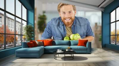 athletic young man holding an apples Wall mural