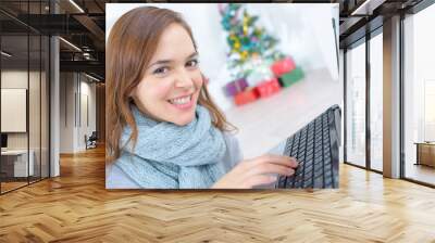 attractive young woman using laptop computer smiling Wall mural