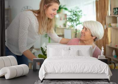 beautiful adult woman is giving flowers to mother Wall mural