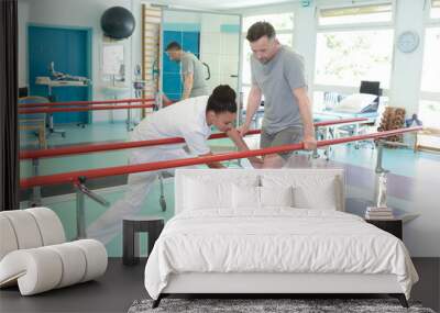 beautiful physiotherapist helping her patient work out on a treadmill Wall mural