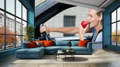 beautiful woman eating an apple while driving Wall mural