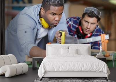 carpenter and apprentice working in studio Wall mural